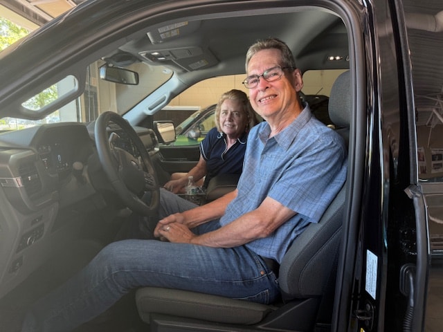 Joe and Mary seated in the front seats of their new 2025 Ford F-150 XLT